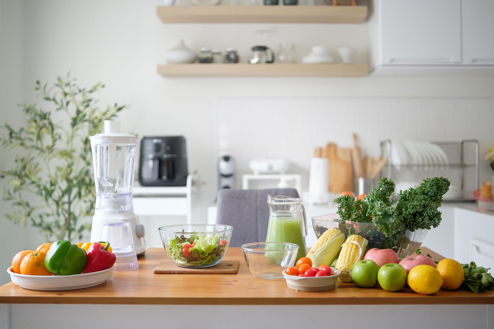 Fresh fruits, vegetables, and a blender on kitchen counter for healthy meal
